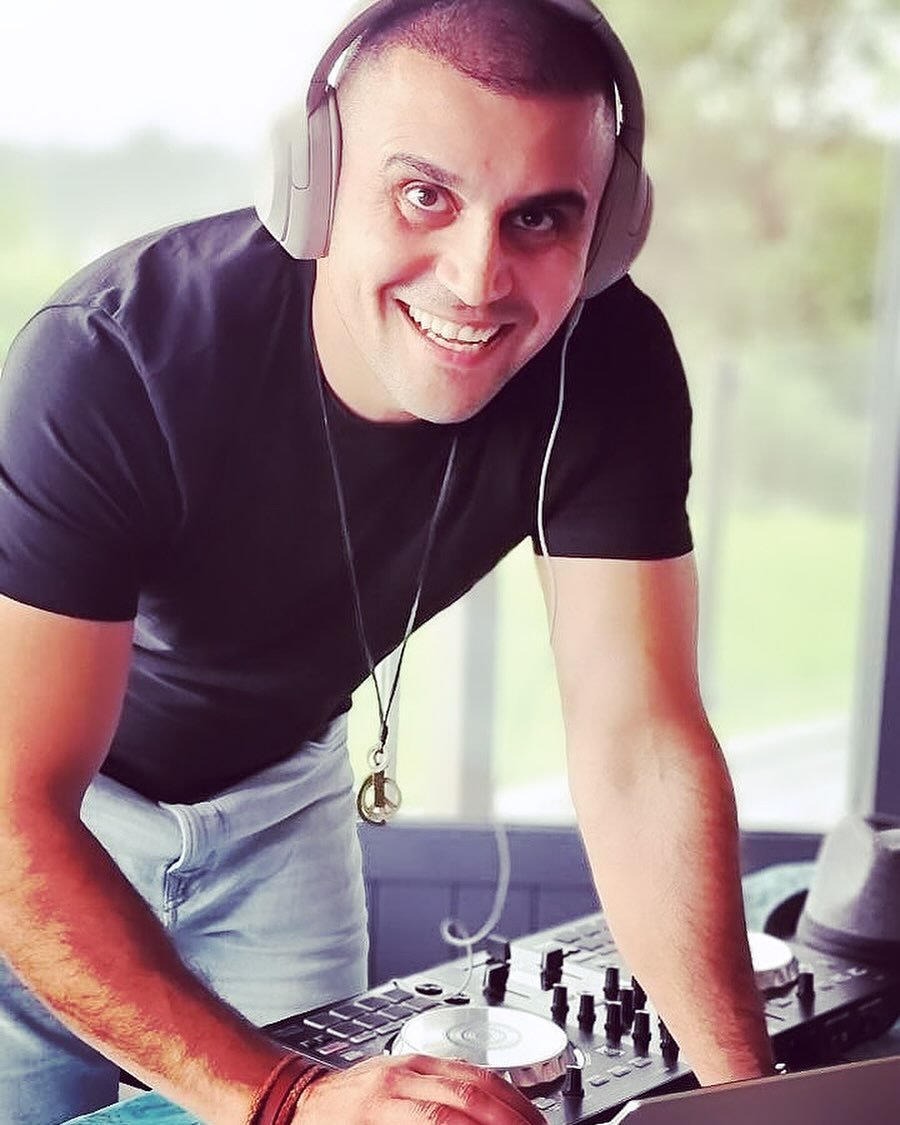 DJ Alphire mixing on his laptop and controller with headphones on.